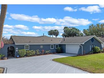 Beautiful single-story home boasts a spacious driveway and well-manicured lawn at 1102 N Palmetto St, Leesburg, FL 34748