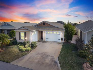 Charming single-story home featuring a well-manicured lawn, a two-car garage, and inviting curb appeal at 1930 Rhett Rd, The Villages, FL 32163