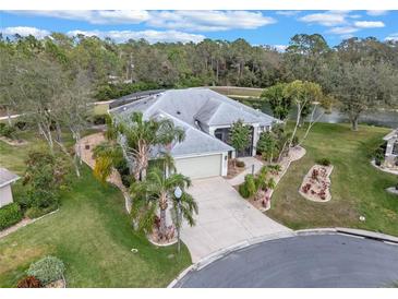 Beautiful aerial view of a well-maintained home featuring a large lot, mature trees, and lake view at 27710 Snow Orchid Ct, Leesburg, FL 34748