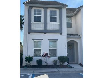 Charming two-story condo featuring gray trim, a welcoming front door, and neat landscaping at 294 Captiva Dr, Davenport, FL 33896