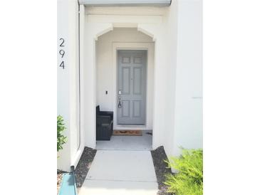 Inviting entryway with a gray front door, welcome mat, and neutral tones at 294 Captiva Dr, Davenport, FL 33896