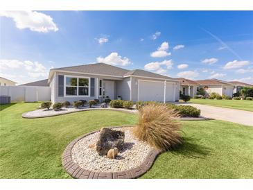 Charming single-story home with well-manicured lawn, attractive landscaping, and attached garage at 3356 Blaise Ter, The Villages, FL 32163