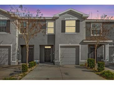 Charming townhouse with gray exterior, single-car garage, and manicured landscaping at 5435 Dragonfly Dr, Wildwood, FL 34785