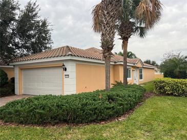 Charming single-story home featuring a tile roof, attached garage, and mature landscaping at 11943 Iselle Dr, Orlando, FL 32827