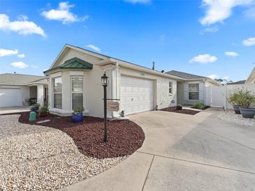 Charming single-story home with a well-manicured front yard and attached garage at 1558 Summerchase Loop, The Villages, FL 32162