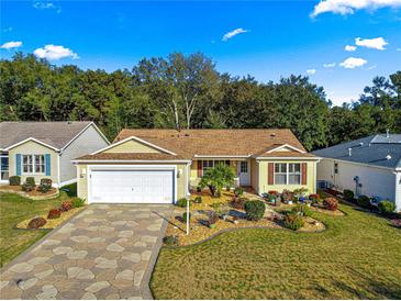 Charming single-story home with a stone driveway, well-manicured lawn, and beautiful landscaping at 2010 Harston Trl, The Villages, FL 32162