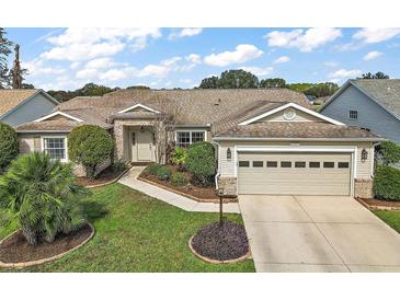 Charming single-story home with a well-manicured lawn and a two-car garage, perfect for comfortable living at 25073 Riverwalk Dr, Leesburg, FL 34748