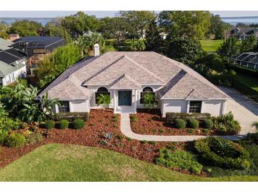 Stunning home featuring a beautiful front yard, well-manicured landscaping, and a charming blue front door at 39136 Harbor Hills Blvd, Lady Lake, FL 32159