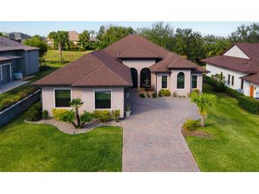 Stunning home featuring a brown roof, lovely landscaping, and a welcoming brick driveway at 5413 Sandy Hill Ln, Lady Lake, FL 32159