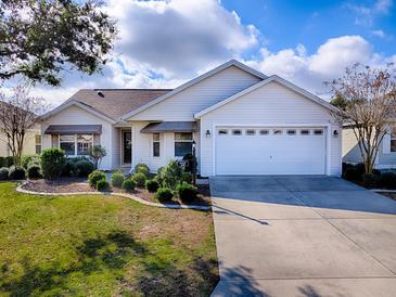 Charming single-story home with white siding, well-manicured lawn, and a two car garage at 610 Mallory Hill Dr, The Villages, FL 32162