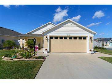 Charming single-story home featuring a well-manicured lawn and a two-car garage at 6576 Merrill Ln, The Villages, FL 34762