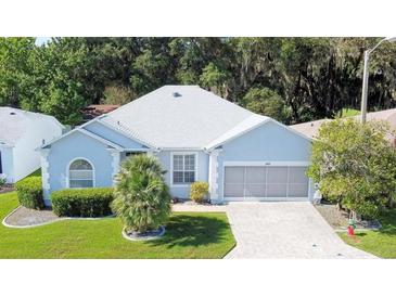 Charming single-story home with a well-manicured lawn and mature landscaping at 726 Grand Vista Trl, Leesburg, FL 34748