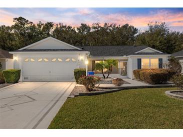 Charming home with a well-manicured lawn, landscaped garden beds, and a welcoming two-car garage at 8373 Se 177Th Bartram Loop, The Villages, FL 32162