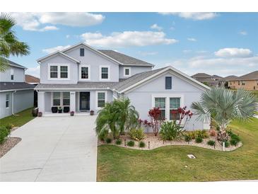 Beautiful two-story home with manicured landscaping, light blue exterior paint and matching shutters at 977 Timberview Rd, Clermont, FL 34715