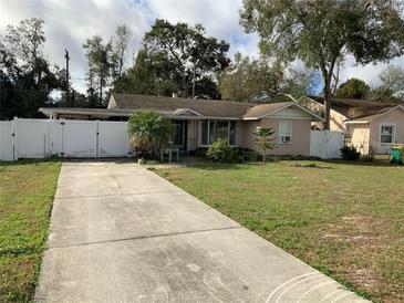 Charming single-story home featuring a long driveway and fenced yard for added privacy at 100 W Idlewild Ave, Eustis, FL 32726