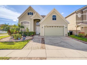 Charming home featuring a two-car garage, well-maintained landscaping, and a welcoming front entrance at 14842 Cedar Branch Way, Orlando, FL 32824