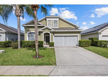 Charming home featuring a well-maintained lawn, a driveway, and mature palm trees in a beautiful neighborhood at 16705 Rolling Green Dr, Clermont, FL 34714