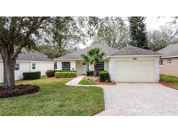 Charming single-story home features a manicured front yard, paver driveway, and attached two car garage at 3847 Eversholt St, Clermont, FL 34711