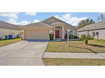 Charming single-story home with a well-manicured front yard and attached two-car garage at 4078 Waltham Forest Dr, Tavares, FL 32778