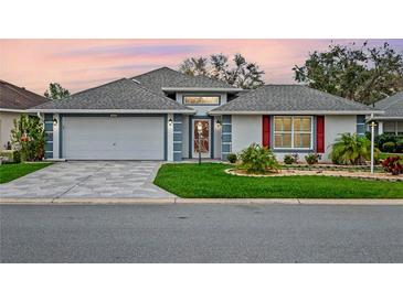 Charming single-story home with a well-manicured lawn and a two-car garage at 4609 Inverness Dr, Leesburg, FL 34748