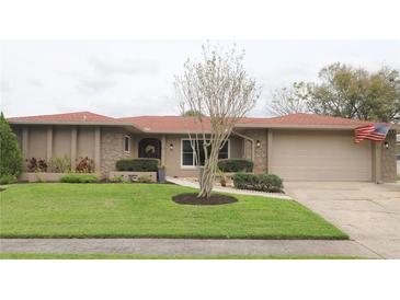 Charming one-story home with a well-manicured lawn, stone accents, and an attached two-car garage at 519 Balsawood Ct, Altamonte Springs, FL 32714