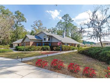 Charming, two-story home featuring a brick facade, manicured landscaping, and an inviting walkway at 5200 Ne 20 St, Ocala, FL 34470