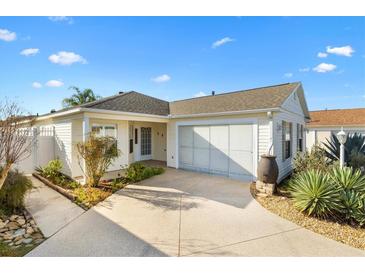 Charming single-story home featuring an attached two-car garage, and a well-manicured landscaped yard with beautiful plants at 544 Audrey Ln, The Villages, FL 32162