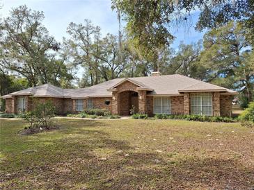 Charming single-story brick home with a well-manicured front yard and mature trees at 580 Mercers Fernery Rd., Deland, FL 32720