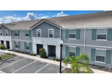 Charming townhouse with gray siding, teal shutters, and well-maintained landscaping at 7581 Oak Spring Ln, Davenport, FL 33837