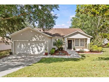 Charming single-story home with a well-maintained lawn and attached two-car garage at 1212 Windy Bluff Dr, Minneola, FL 34715