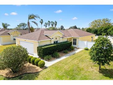 Beautiful single-story home featuring a well-manicured lawn and lush landscaping at 1622 Valley Falls Way, The Villages, FL 32162