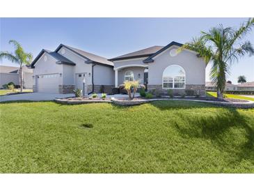Charming single-story home with well-manicured lawn, attractive landscaping, and neutral-tone exterior at 17204 Se 112Th Court Rd, Summerfield, FL 34491