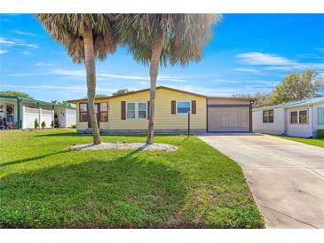 Charming single-story home featuring a well-manicured lawn and beautiful palm trees enhancing curb appeal at 1854 W Schwartz Blvd, Lady Lake, FL 32159