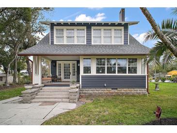 Charming two-story home featuring a cozy front porch, beautiful landscaping, and a well-maintained lawn at 219 W 9Th Ave, Mount Dora, FL 32757