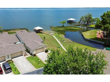 Stunning aerial view of waterfront home with private dock, lush landscaping, and access to beautiful blue waters at 2229 Cypress Ct # C-4, Tavares, FL 32778