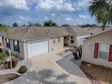 Charming single-story home featuring a two-car garage and a well-manicured lawn, creating a welcoming curb appeal at 2367 Camden Ter, The Villages, FL 32162