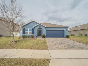 Charming single-story blue home with a well-manicured lawn and a paved driveway at 3339 Landing Vw, Tavares, FL 32778
