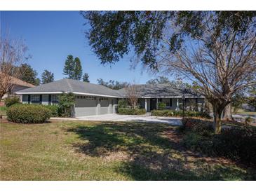 Charming one-story home featuring a manicured front lawn and a spacious driveway at 10648 Lake Hill Dr, Clermont, FL 34711