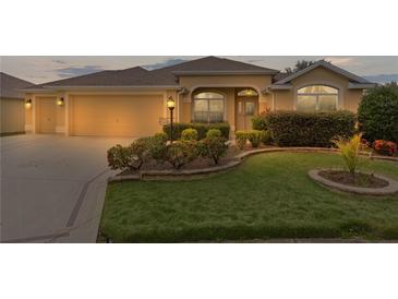 Charming single-story home featuring a two-car garage and beautifully landscaped front yard at 1938 Sassparilla Way, The Villages, FL 32162