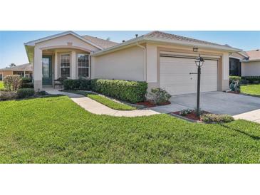 Charming single-story home featuring a well-manicured lawn and a two-car garage at 27536 Stoney Brook Dr, Leesburg, FL 34748