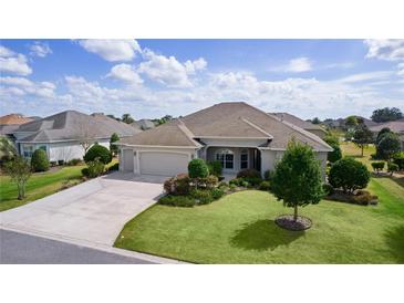 Charming single-story home featuring a well-maintained lawn and an attached two-car garage at 2935 Cedar Grove Loop, The Villages, FL 32163
