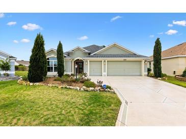 Charming single-story home featuring a well-manicured lawn, tasteful landscaping, and a spacious three-car garage at 3233 Belcherry Loop, The Villages, FL 32163