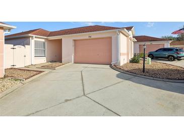 Exterior view of home showing a two-car garage and a well-maintained driveway at 731 Hernandez Dr, The Villages, FL 32159