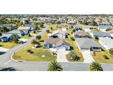 Expansive aerial view of a vibrant residential community with well-maintained lawns and mature landscaping at 909 Abaco Path, The Villages, FL 32163