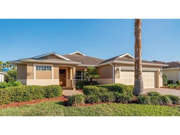 Charming single-story home featuring a manicured lawn, two-car garage, and neutral tones at 10105 Ketch Kay Ln, Oxford, FL 34484