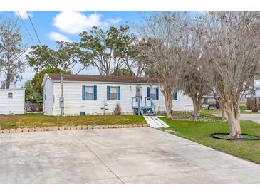 Charming single-story home with a well-maintained yard and a ramp for easy access at 12221 Helena Ct, Leesburg, FL 34788