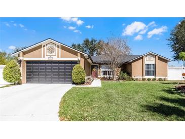 Charming single-story home with a well-manicured lawn and inviting curb appeal on a sunny day at 15307 Petrus Ln, Clermont, FL 34714