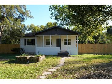 Charming single-story home with a cozy front porch and stone walkway leading to the entrance at 2210 Grant Ave, Eustis, FL 32726