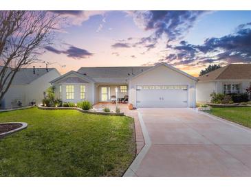 Charming one-story home featuring manicured lawn, lovely landscaping, and a two-car garage at 3176 Atwell Ave, The Villages, FL 32162