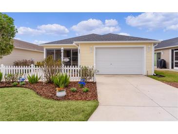 Charming home featuring a two-car garage, beautiful landscaping, and a well-maintained lawn at 620 Vagabond St, The Villages, FL 32163